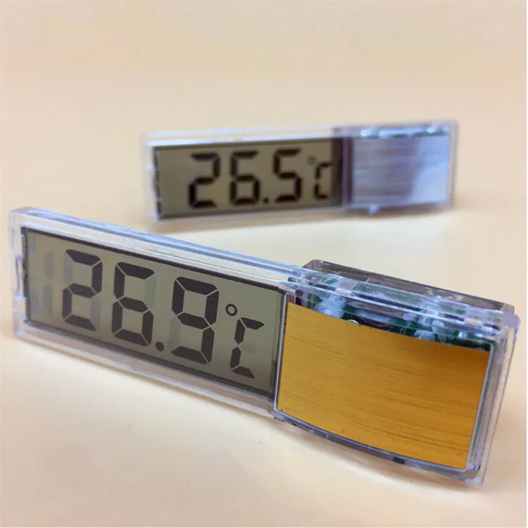 Gold digital stick-on aquarium thermometer on glass tank showing temperature reading