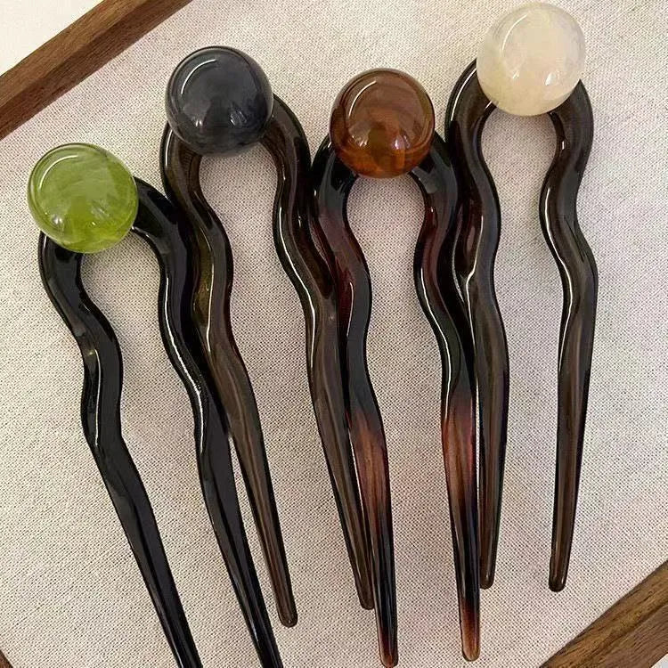 Acrylic U-shaped hair barrette with a retro ball design in a simple style.