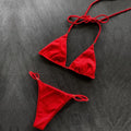 Women's nylon split bikini in red, backless triangle cut, on model at beach