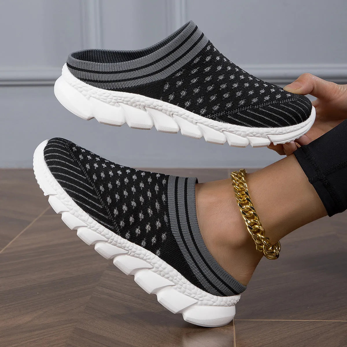 Women's Flyknit slipper shoes in a stripe pattern, showing hollowed-out design and sewing lines, on a viscose sole.