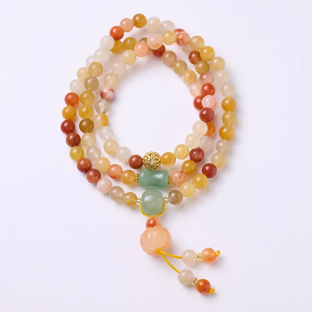 Women's handcrafted Jinsi Jade bracelet with pumpkin-shaped beads and tassels on a wrist.