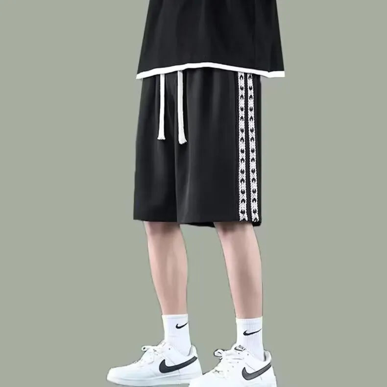 Man wearing black loose-fit baggy track pants, showcasing the casual sports style and roomy cut.