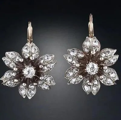 A pair of silver retro-style drop earrings for women on a white background.