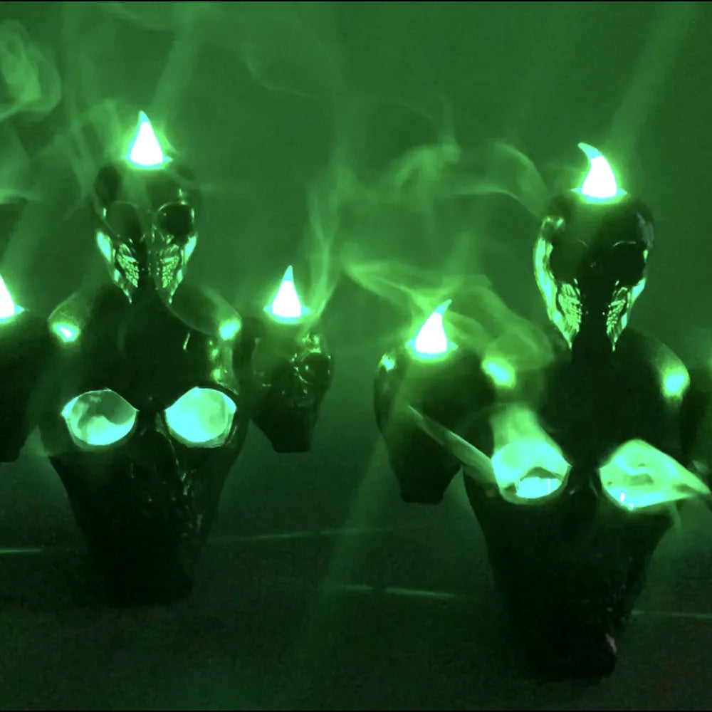 Golden skull ornament with LED light shaped like a skeleton hand holding a candle