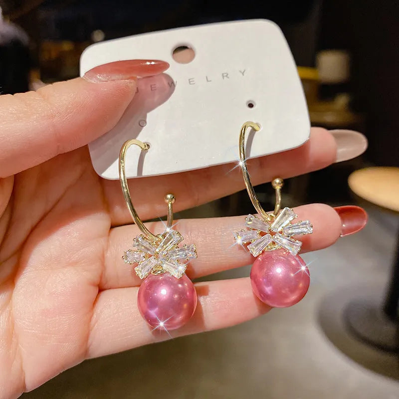 Women's bowknot stud earrings with rhinestone detail in Blue Pink Red White, alloy electroplated, individually packed.