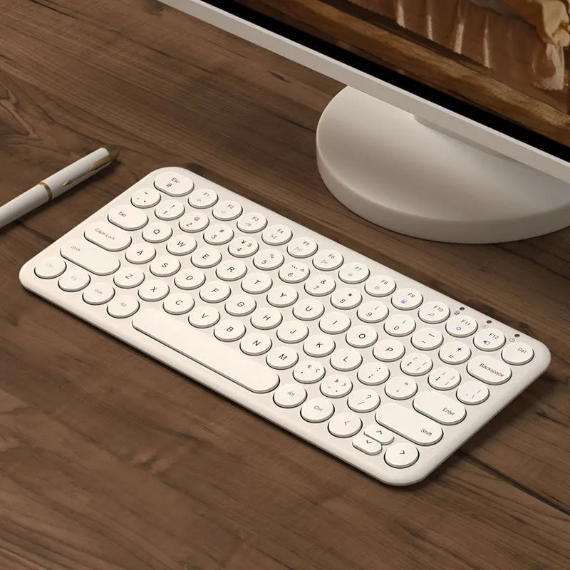 White ultra-thin wireless keyboard and mouse set with a single USB receiver on a wooden desk.