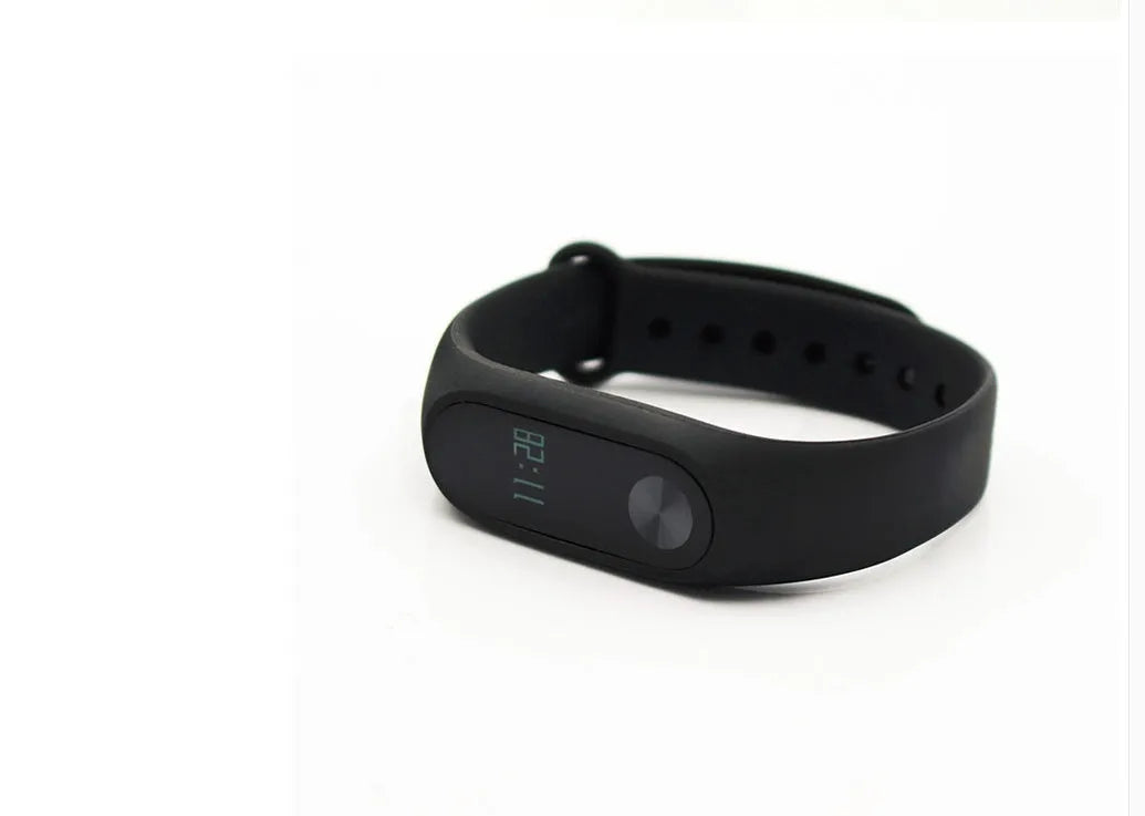 Xiaomi Mi Band 2 black fitness tracker on wrist showing OLED display with heart rate reading.
