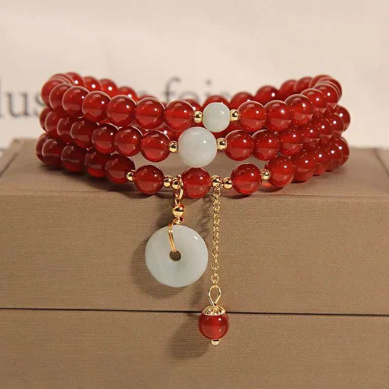 Women's multi-layer red agate crystal bracelet with adjustable closure on a wrist.
