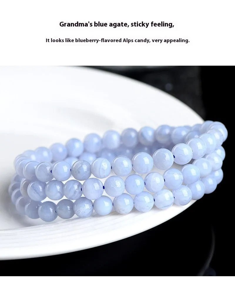 Close-up of a blue striped agate beaded bracelet with Ruyi design on a neutral background.