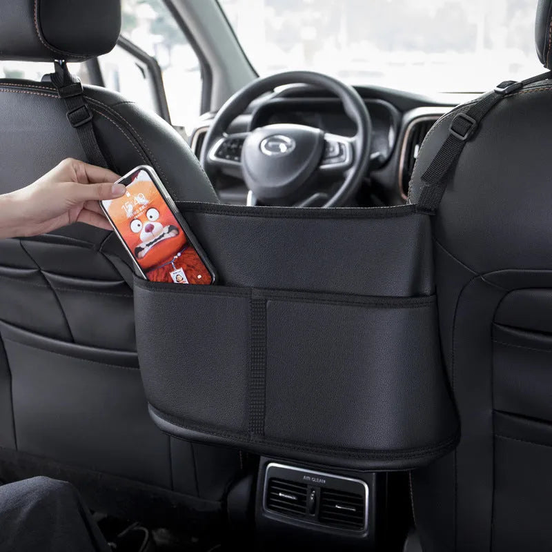 Black leather car seat storage bag with a carbon fibre pattern, showing its size next to a car seat.