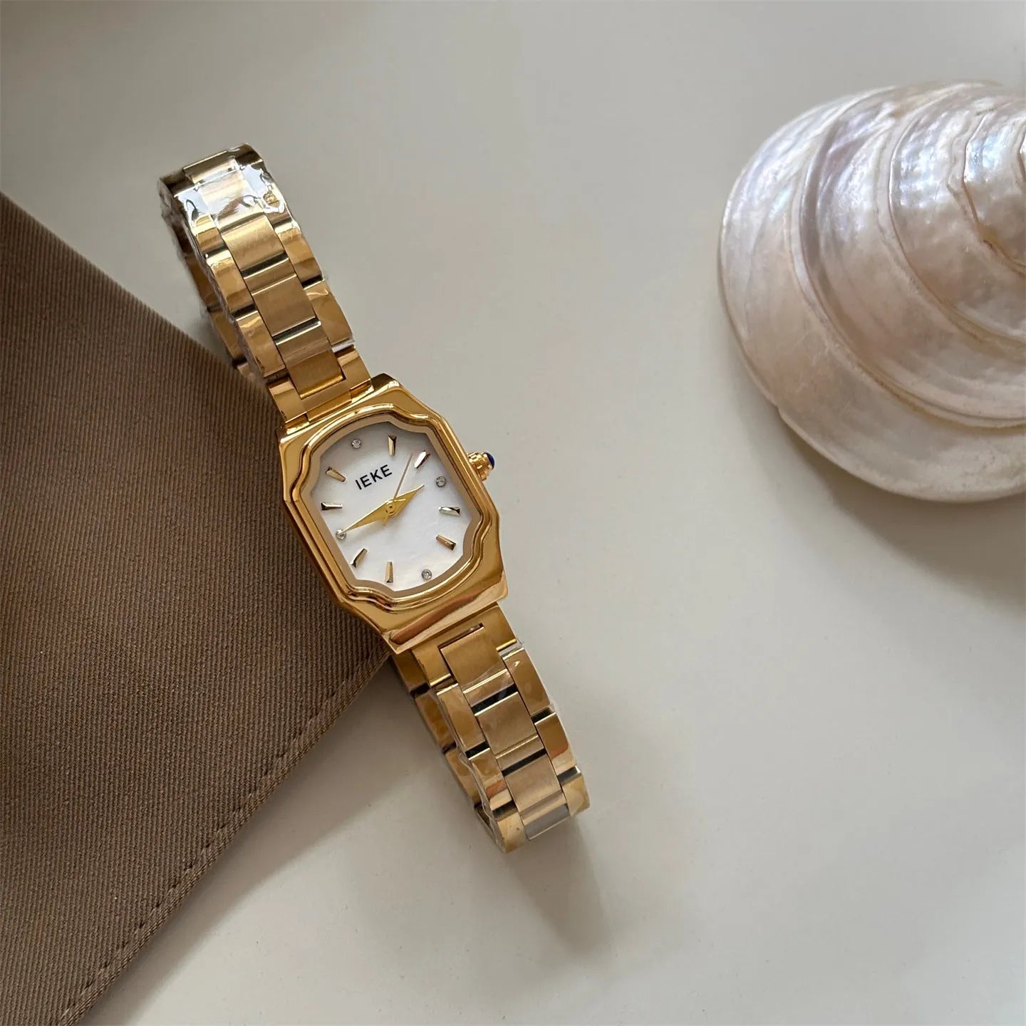 Women's small square watch with gold strap and green dial, 10mm thin, on wrist