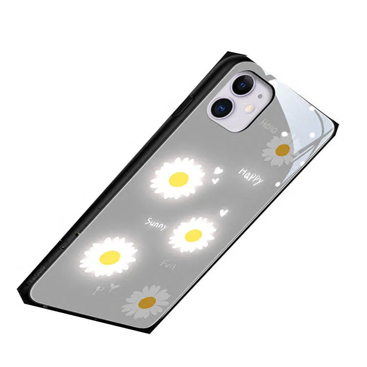 White iPhone case with painted daisies and a voice-activated coloured light strip on the back.