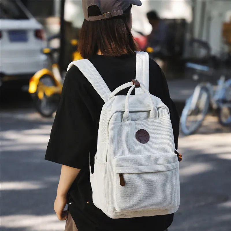 Retro unisex corduroy backpack in solid colour with breathable fabric, side view.