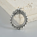 Pair of large antique silver dragon-shaped earrings with geometric hollow-out design on a white background.