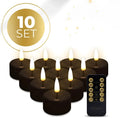 Set of four black plastic LED tealight candles showing flickering light effect.