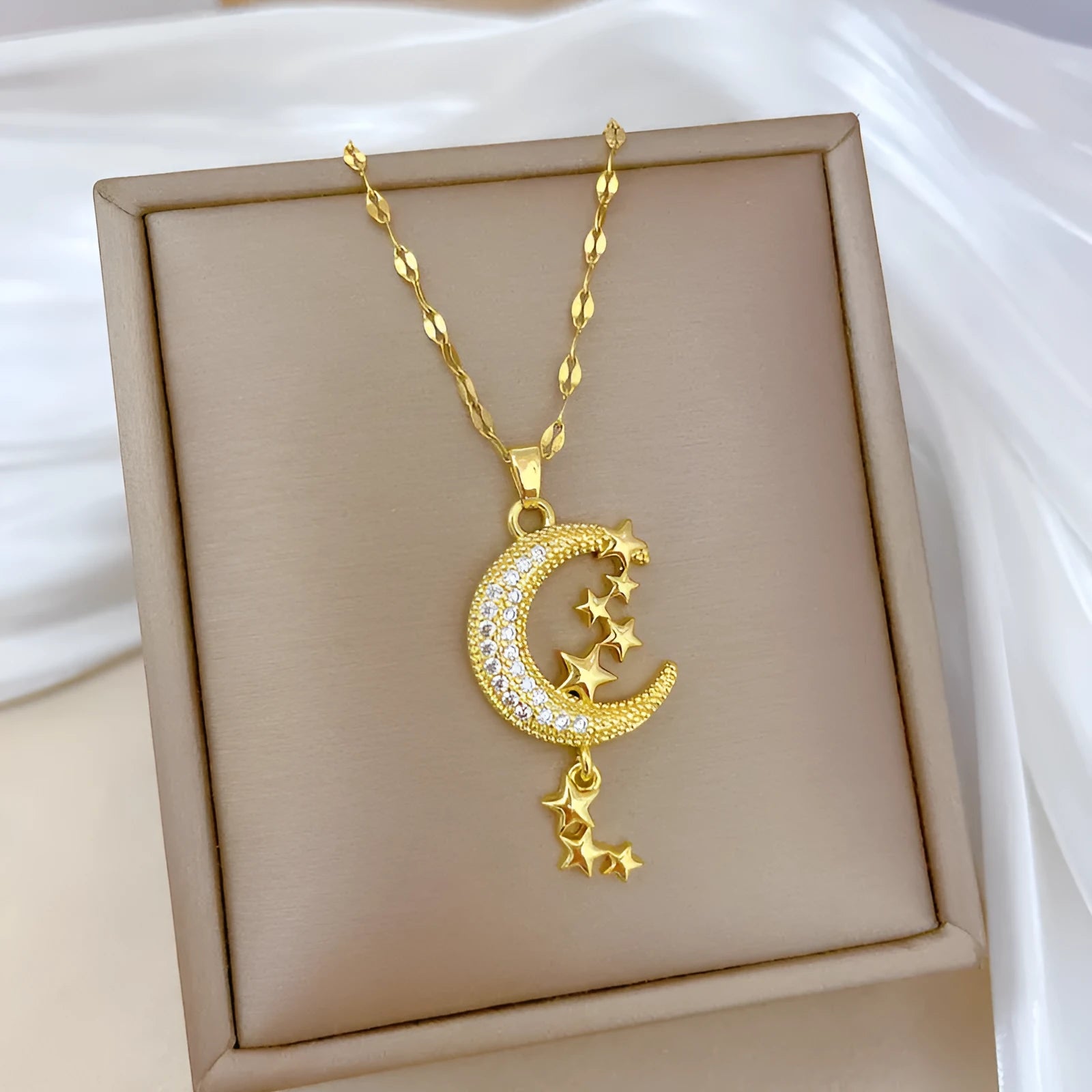Geometric openwork moon pendant necklace with a linear crystal tassel on a silver stainless steel chain.