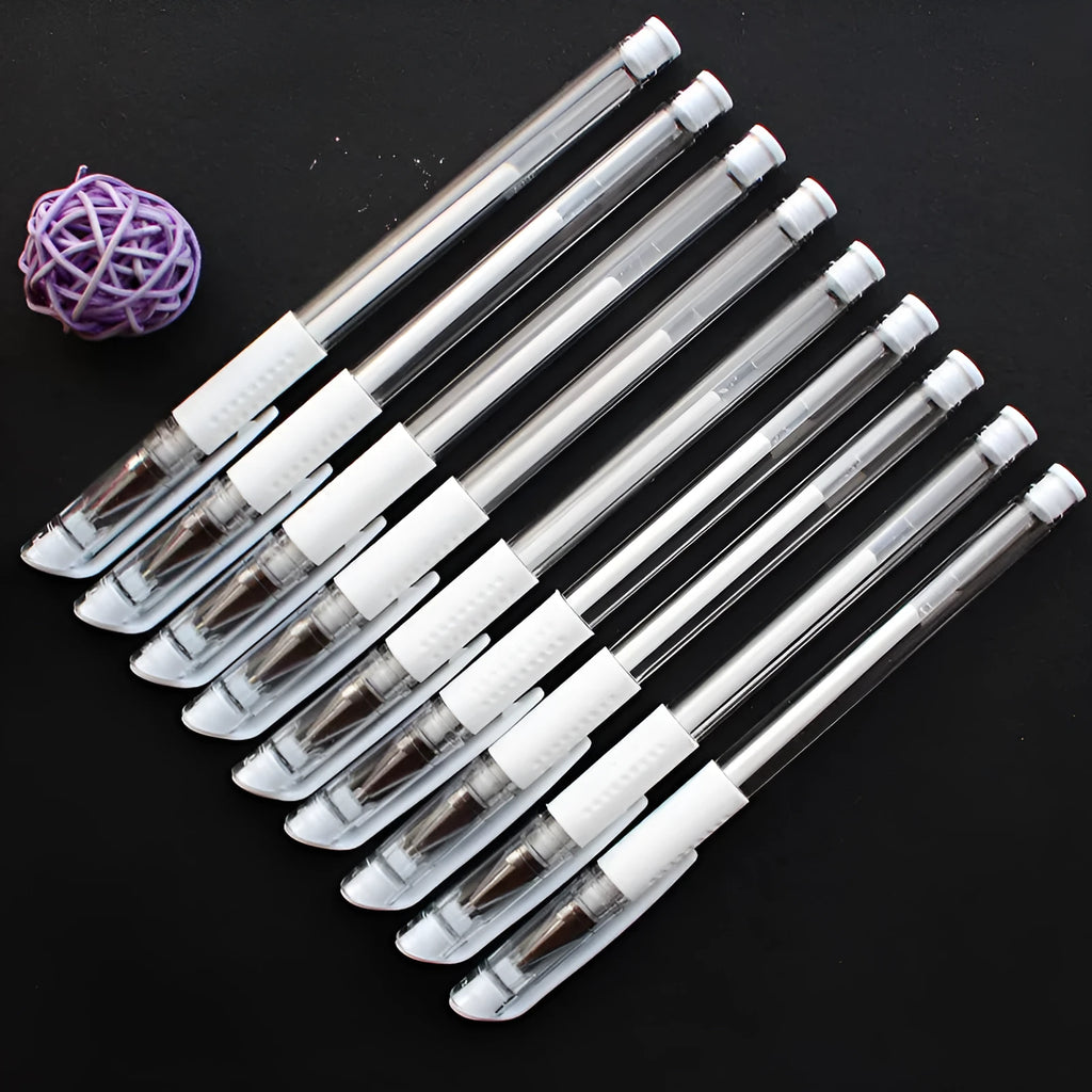 White hard pen calligraphy pen with cap closure on a dark surface showing white ink lines