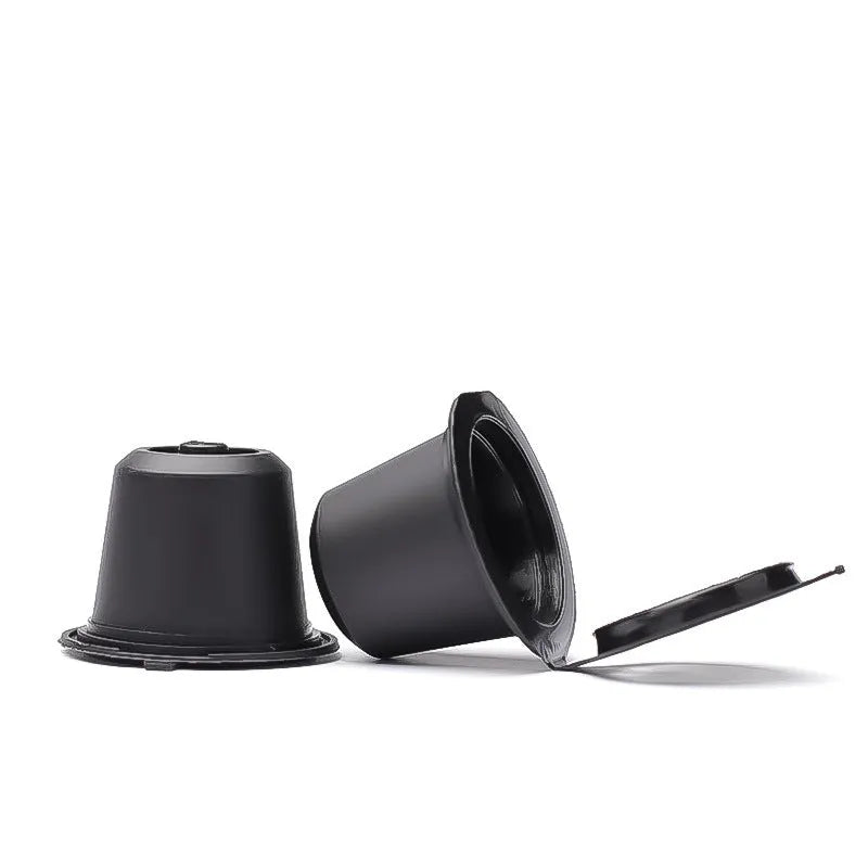 Set of six recyclable reusable plastic coffee filter cups in black, brown, and red with a spoon on wooden background