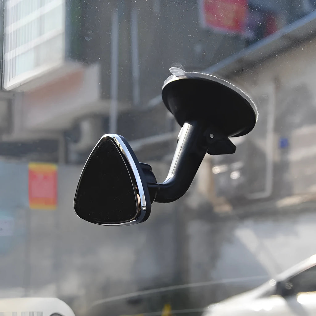 Classic black magnetic car phone holder mounted on a car dashboard, showing 360-degree rotation.