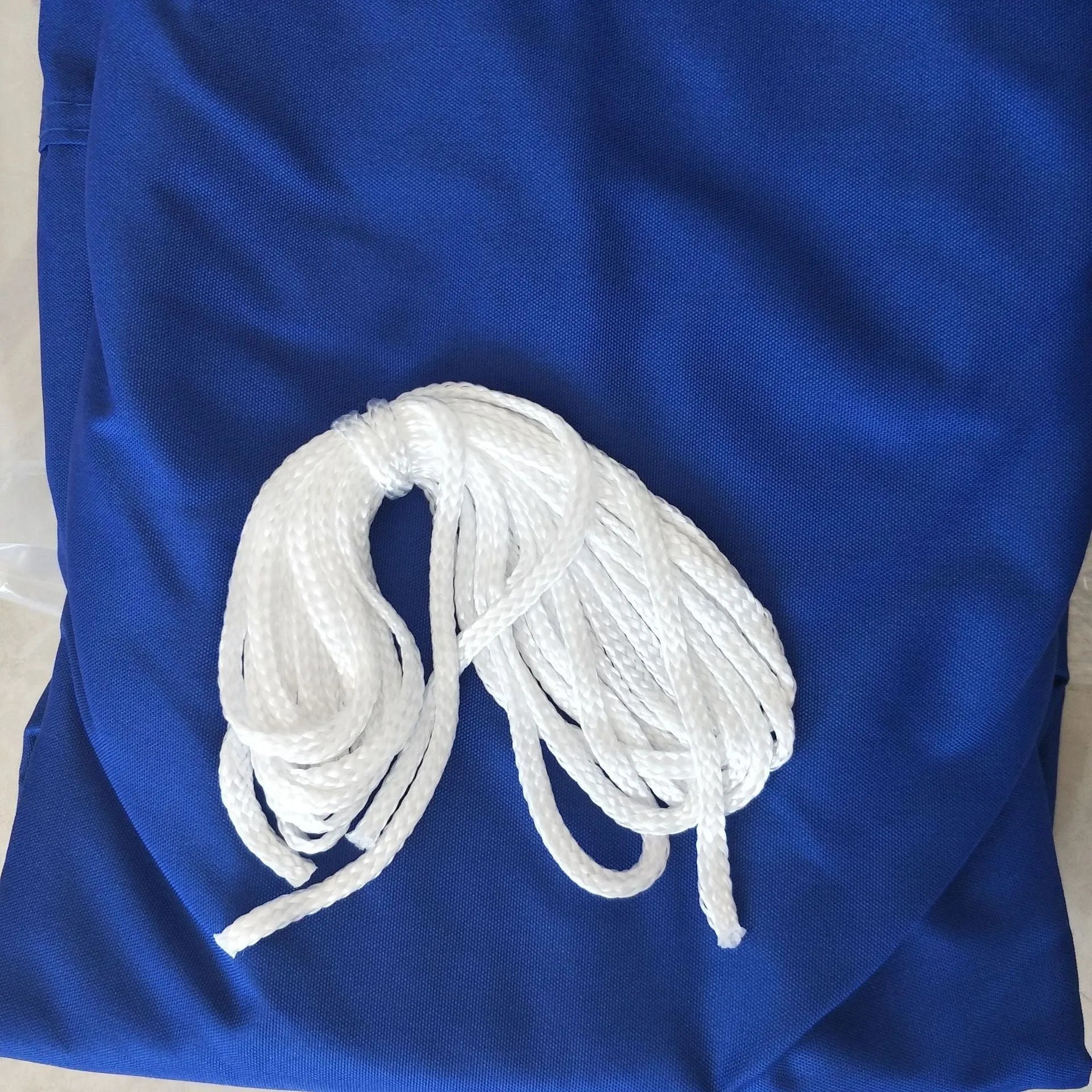 Blue curved square polyester shade sail measuring 3 metres by 4 metres for outdoor UV protection