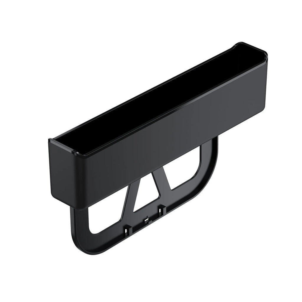 Plastic car seat gap storage box organiser in black, shown placed between a car seat and centre console.