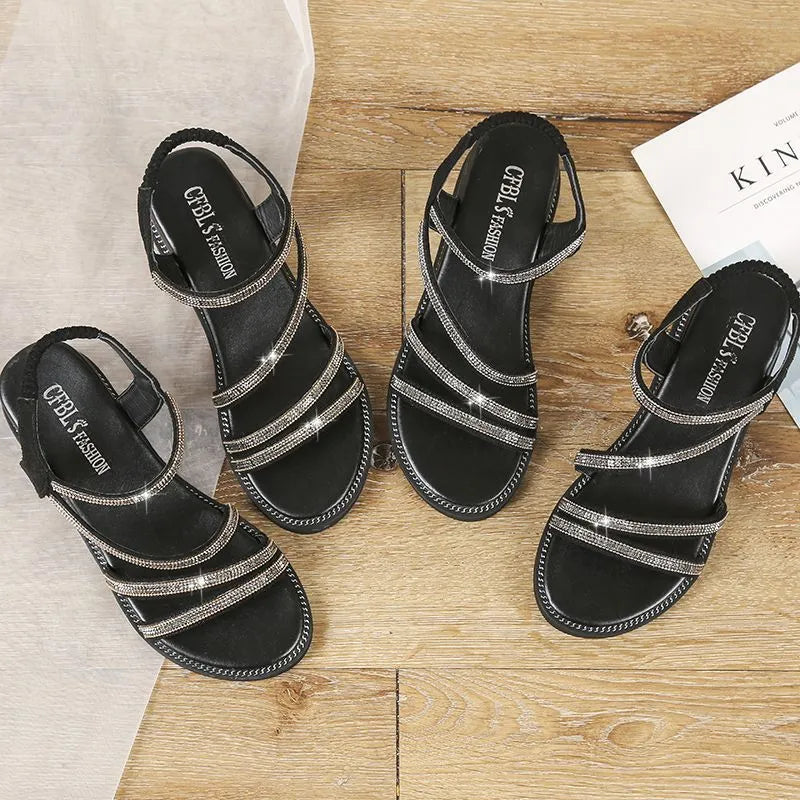 Women's silver flat sandals with rhinestone details and a non-slip rubber sole.