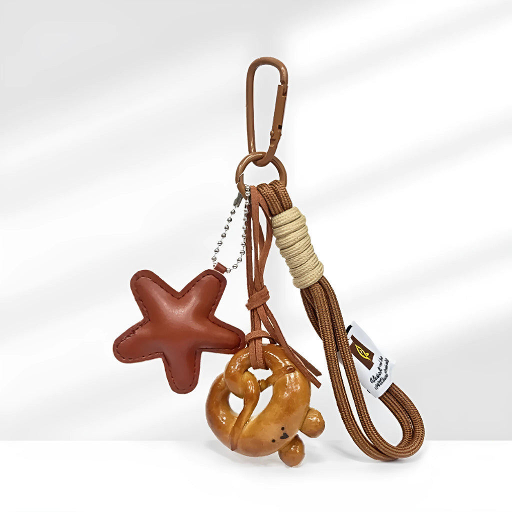 Handmade soda bread style handbag pendant with a cartoon design on a brown carrying strap.