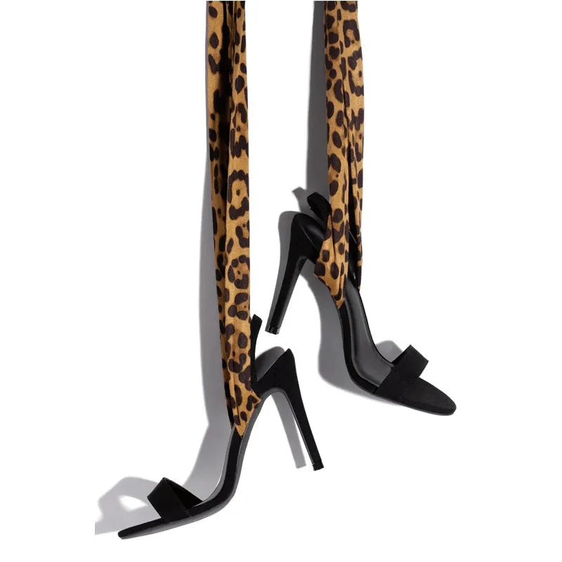 Light brown leopard print women's high heel sandals with cross-straps and a thin 8cm stiletto heel on a rubber sole.