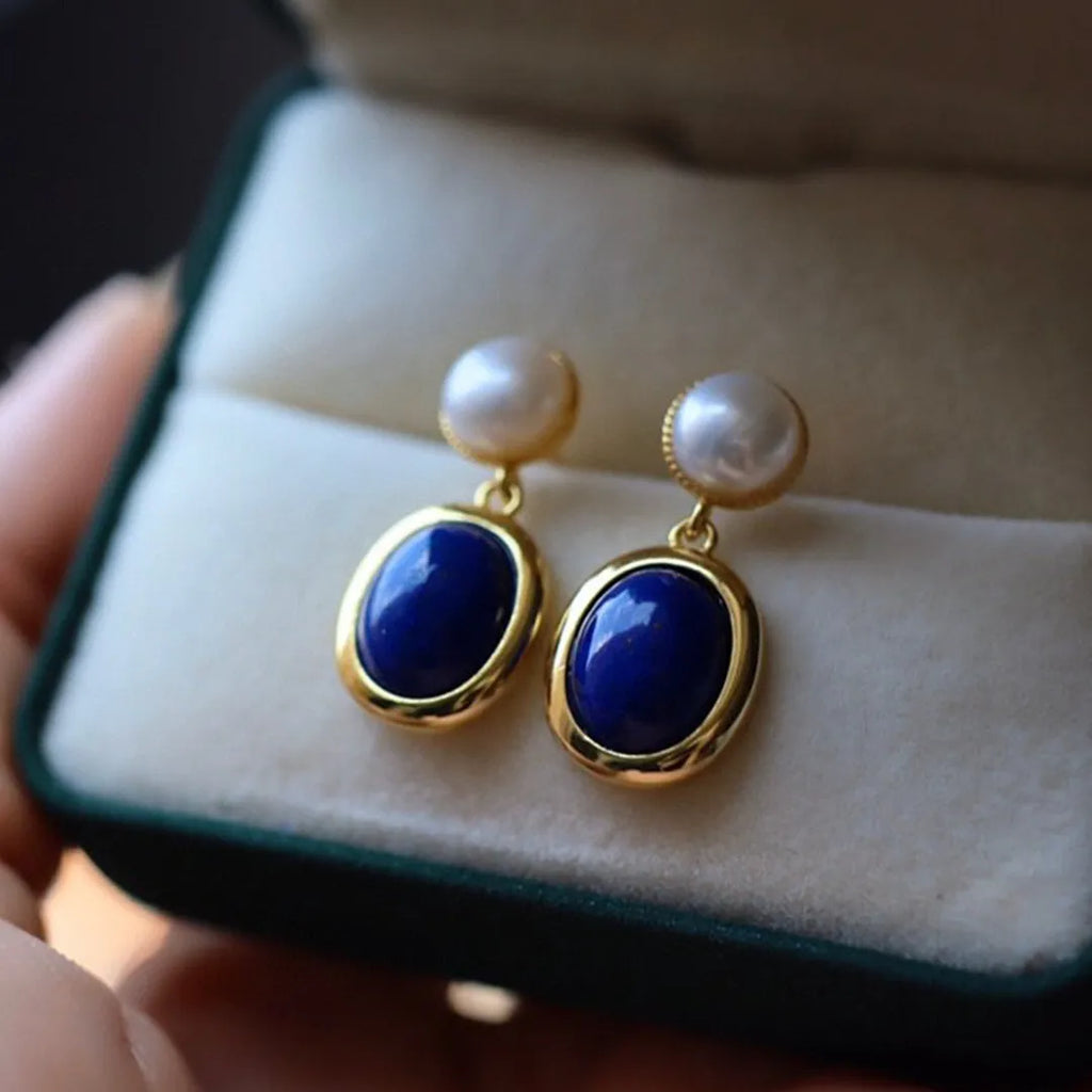 A pair of sterling silver drop earrings with a blue lapis lazuli pearl and auspicious patterns.