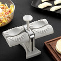 White double-head manual dumpling maker with anti-slip rubber base on a kitchen counter.