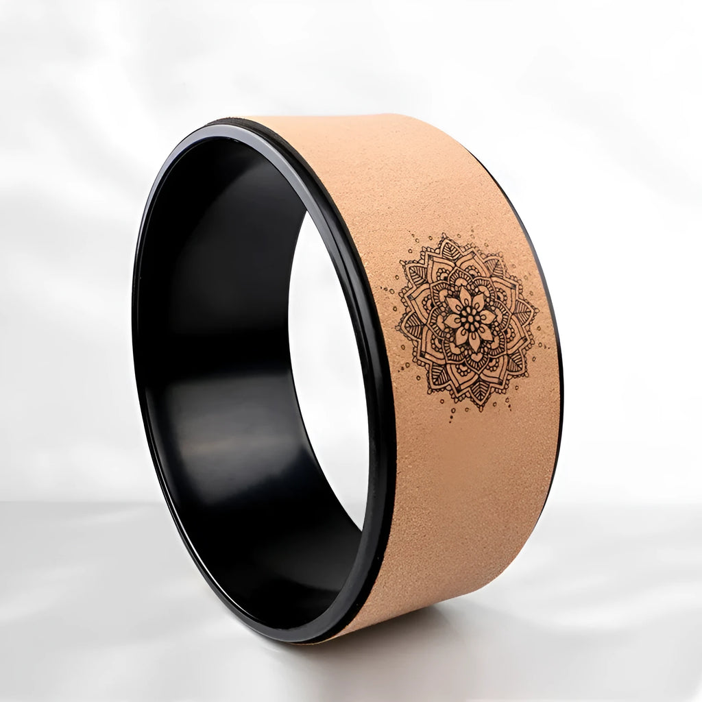 Brown cork yoga wheel with Mandala flower design on a wooden floor