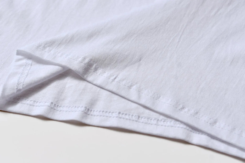 White cotton pullover overalls with short sleeves and a round neck, shown on a hanger.