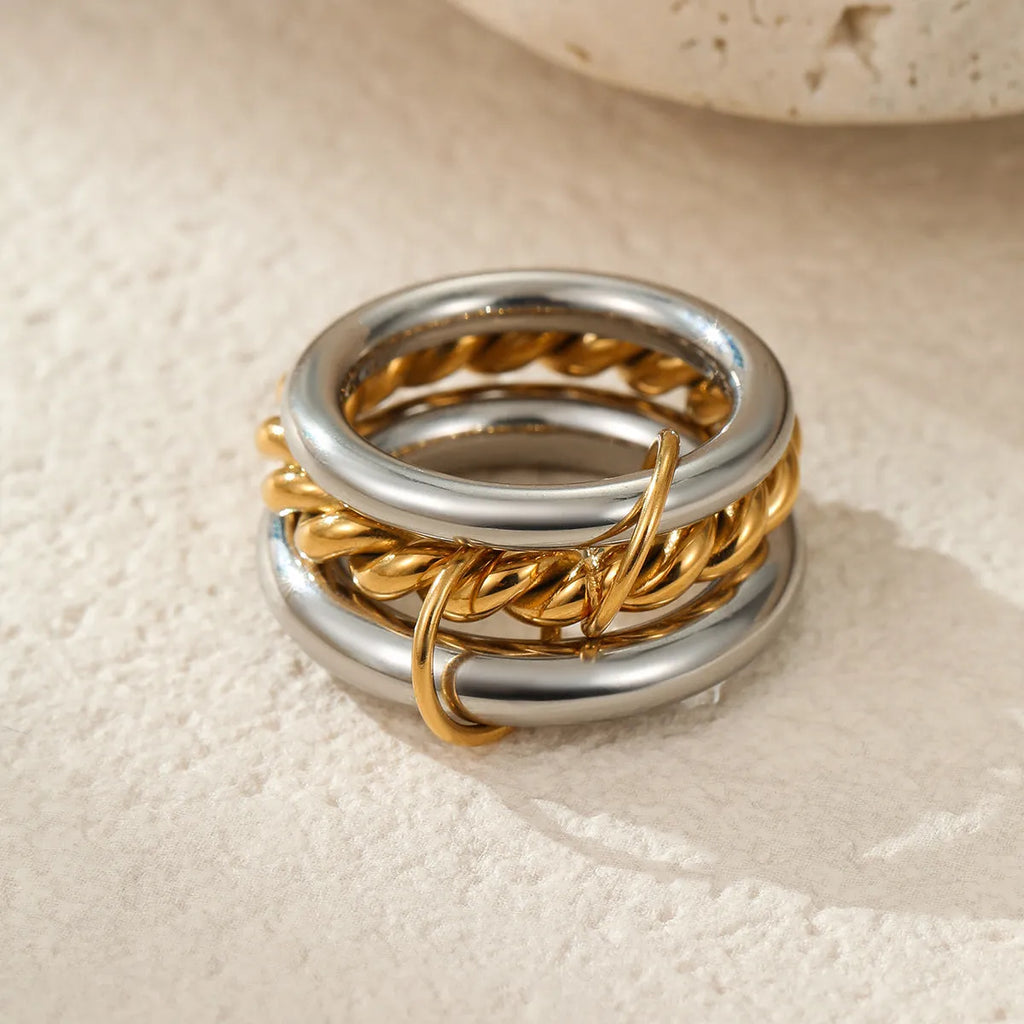 Stacked stainless steel rings with 18K gold plating in an exaggerated silhouette design.