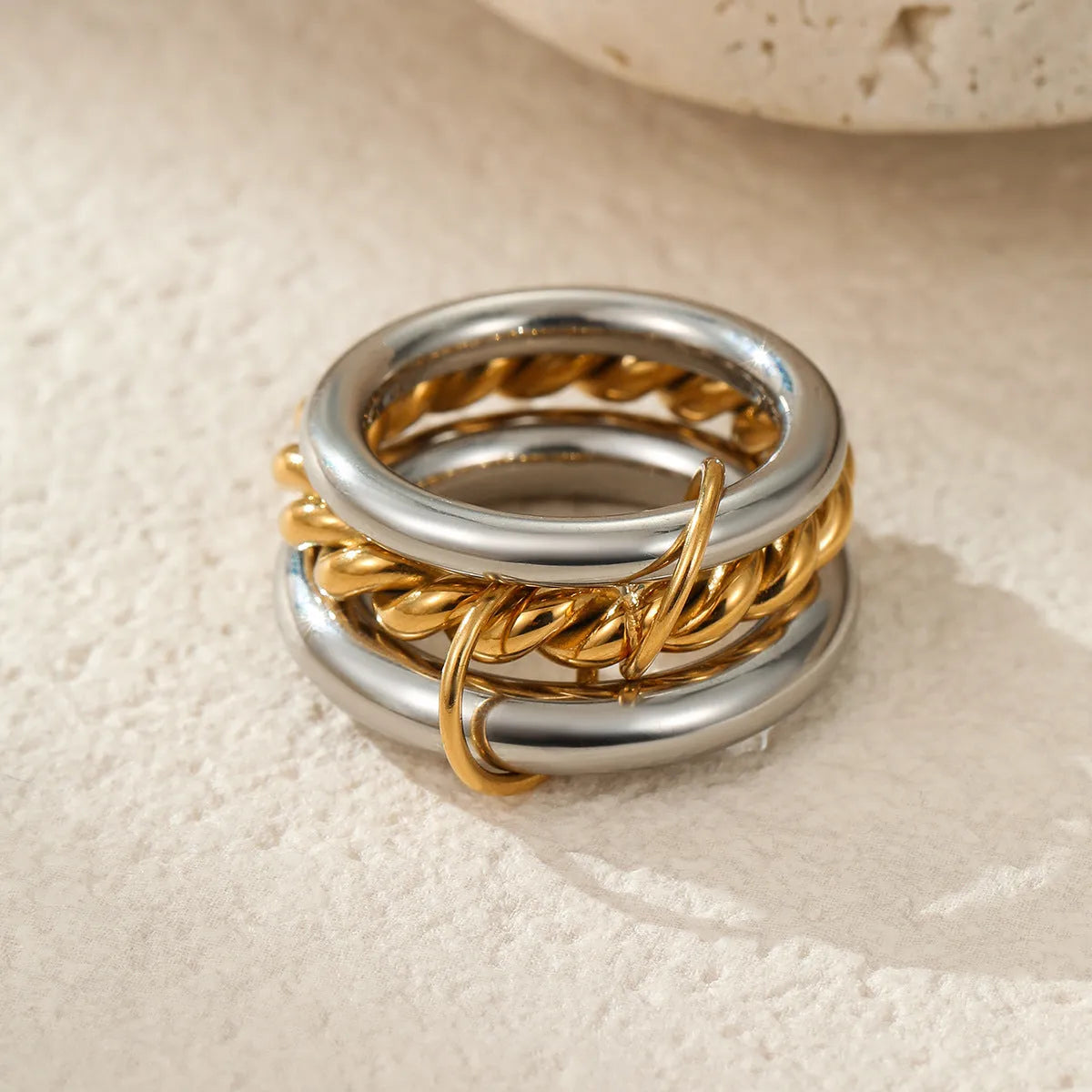 Stacked stainless steel rings with 18K gold plating in an exaggerated silhouette design.