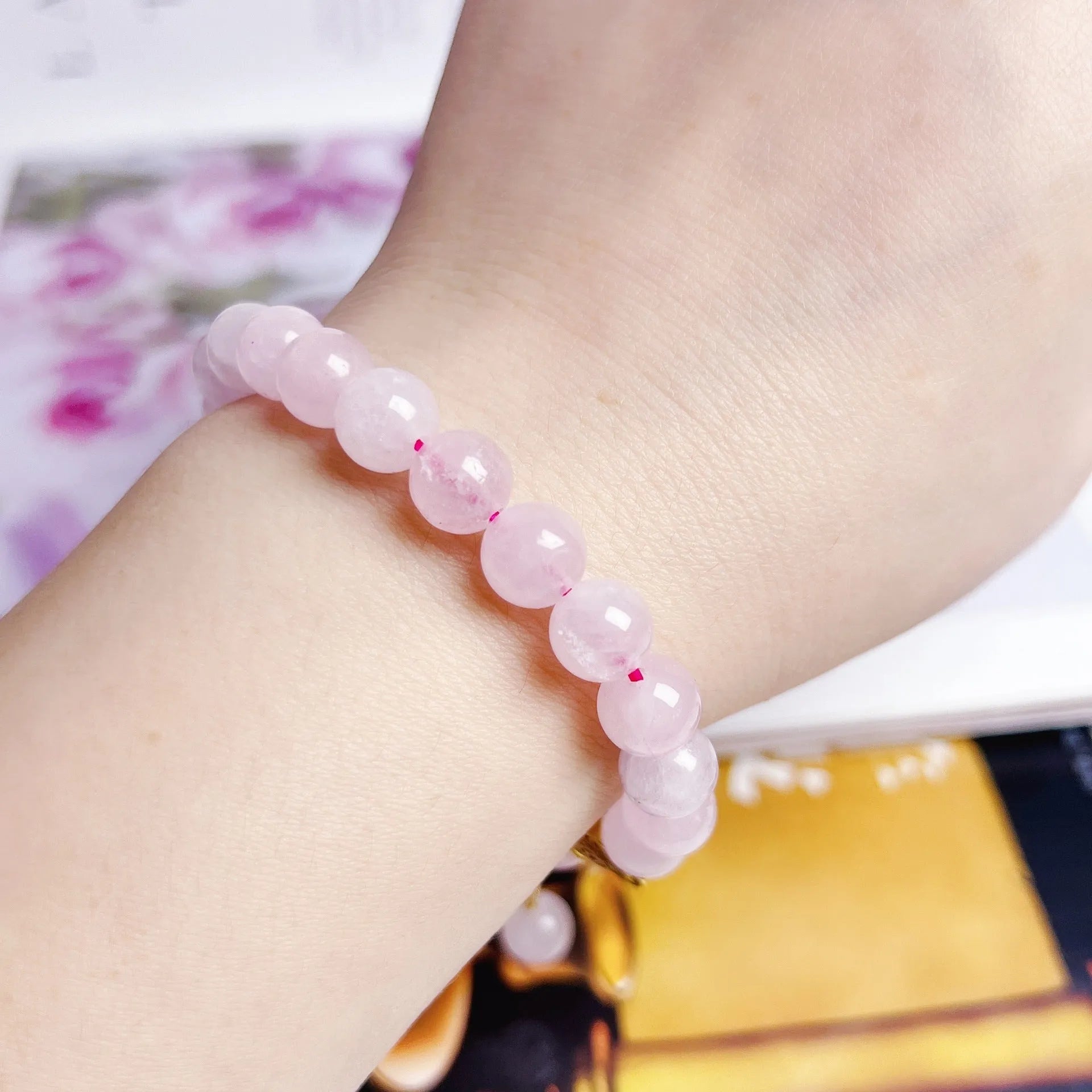 Pink crystal peach blossom bracelet with adjustable sliding knot closure on wrist