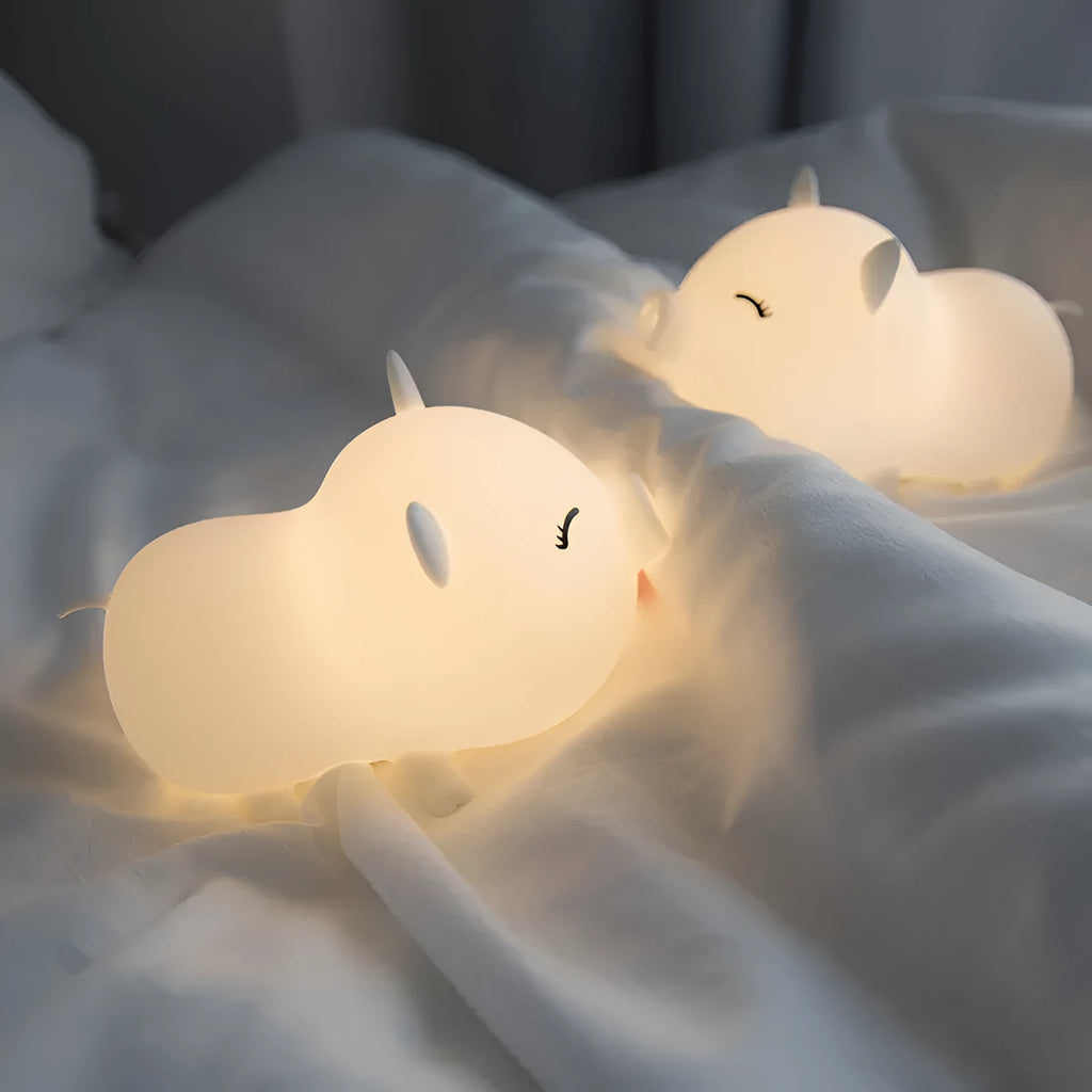 Dudu pig cartoon night light with silicone lampshade and warm yellow LED glow on a bedside table