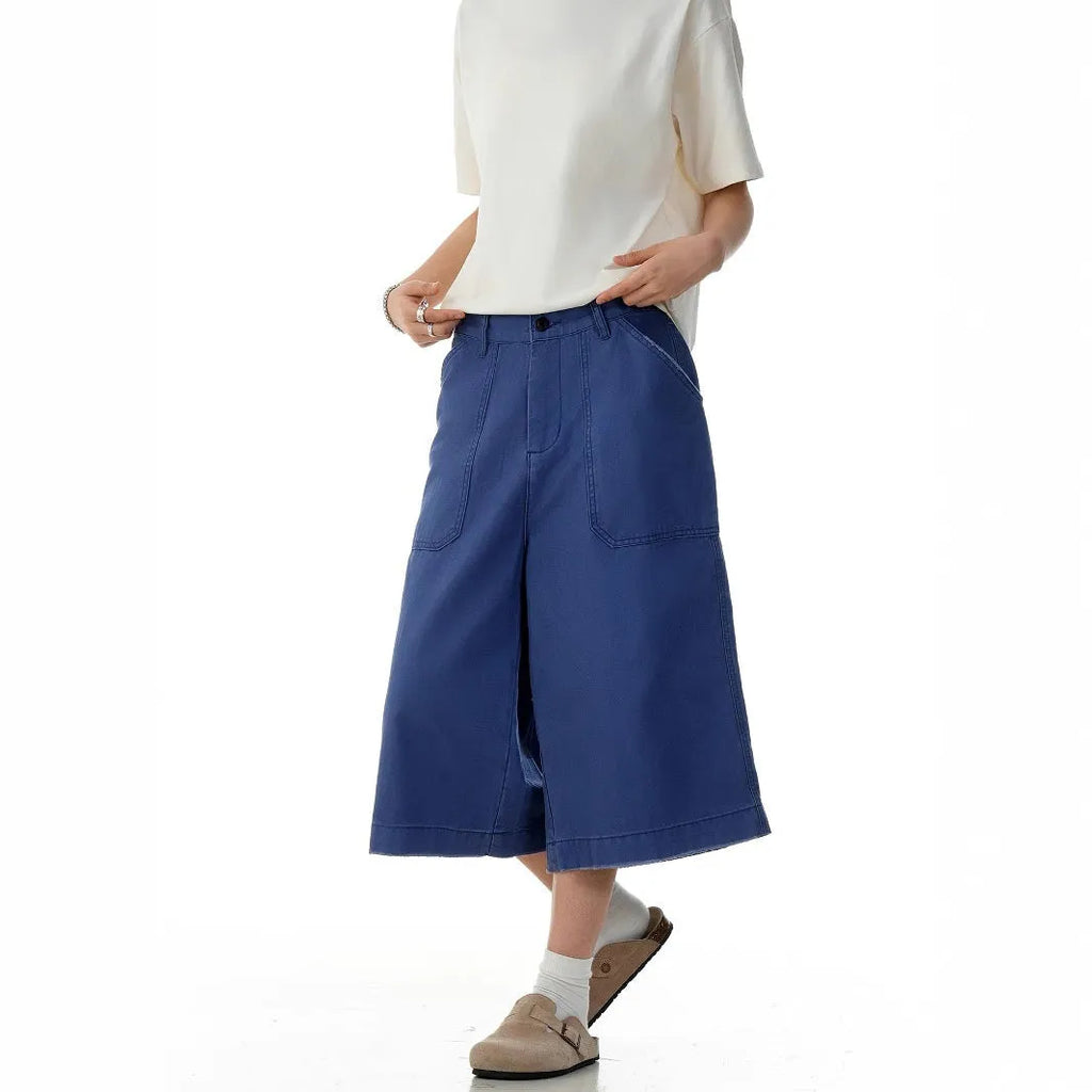 Men's French blue cotton shorts, loose straight-leg fit, mid-rise waist with zipper fly, lying flat.