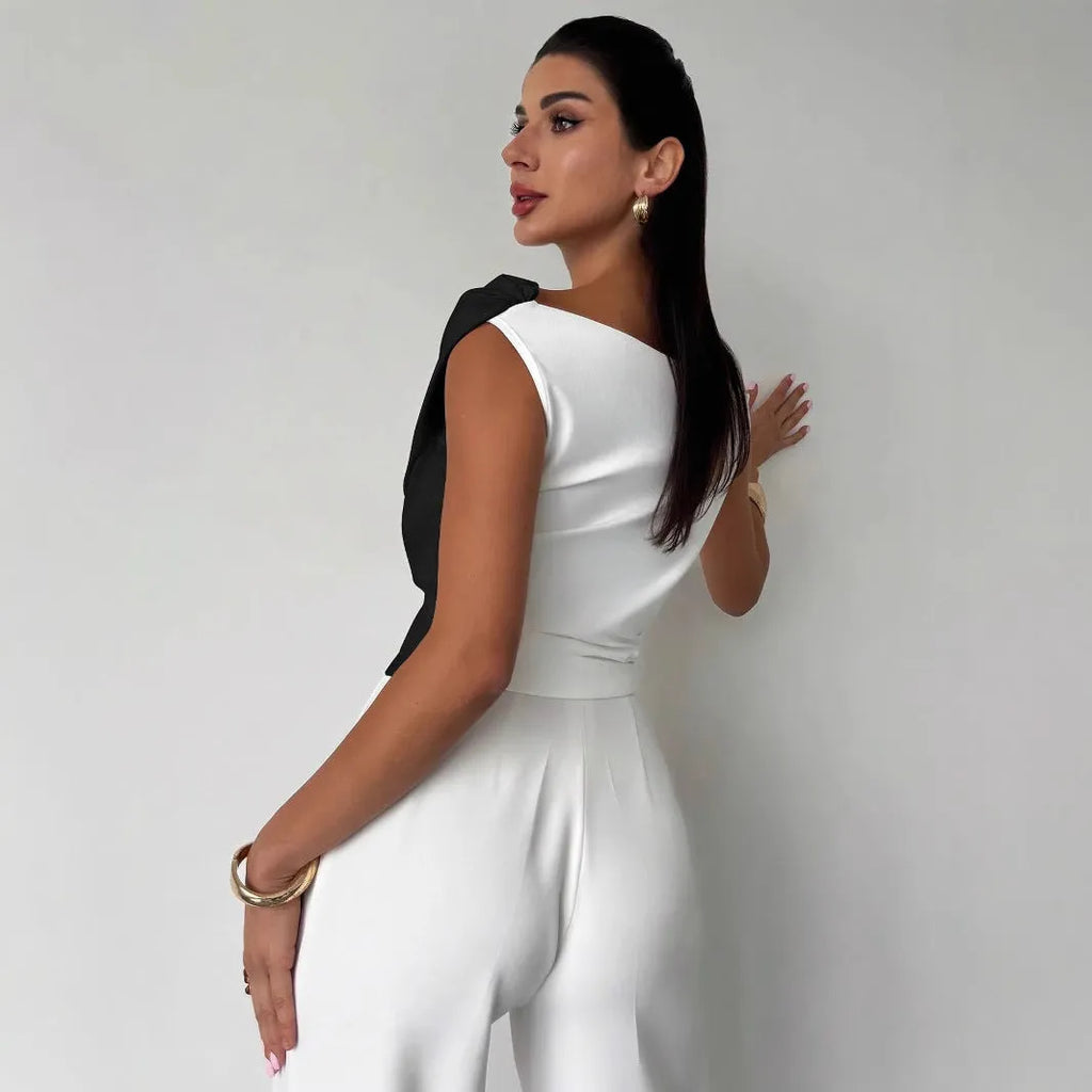 Color-blocked women's top with asymmetric shoulder and ruffled hem, slim fit, black with white panels, polyester fabric.