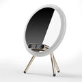 Multi-function LED mirror alarm clock with wireless charger and Bluetooth speaker in white colour on wooden desk