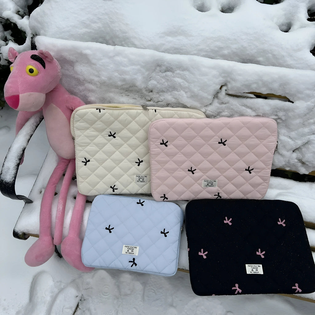 White nylon laptop bag with a light blue embroidered rhombus bow on the front