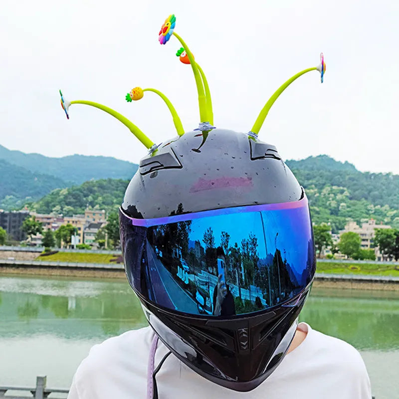 Yellow silicone sunflower helmet decoration with swinging stem and suction cup on a visor.