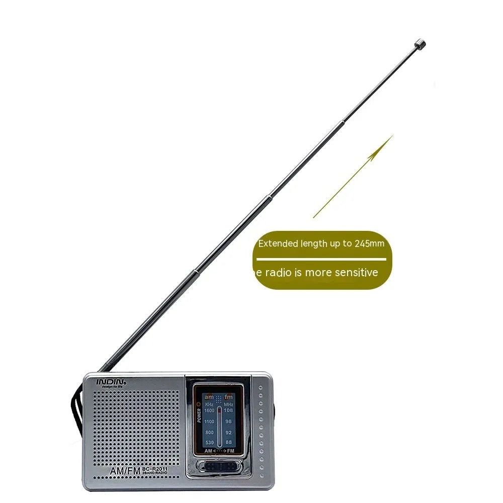 Portable silver grey FM AM radio on table, compact ABS body with built-in speaker and dial controls