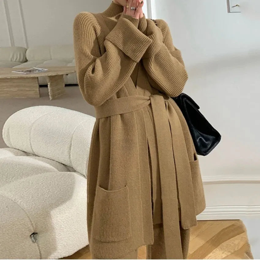 Women's apricot knitted cardigan, top, and wide-leg trousers set with black leather stitch trim detail.