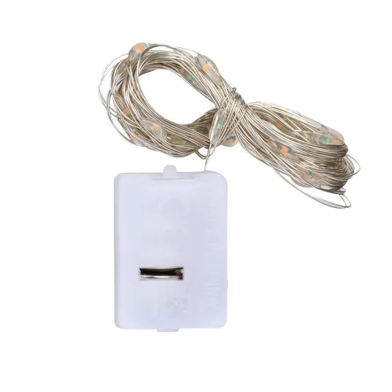 LED copper wire light string with warm white floral-shaped lamps on a dark background