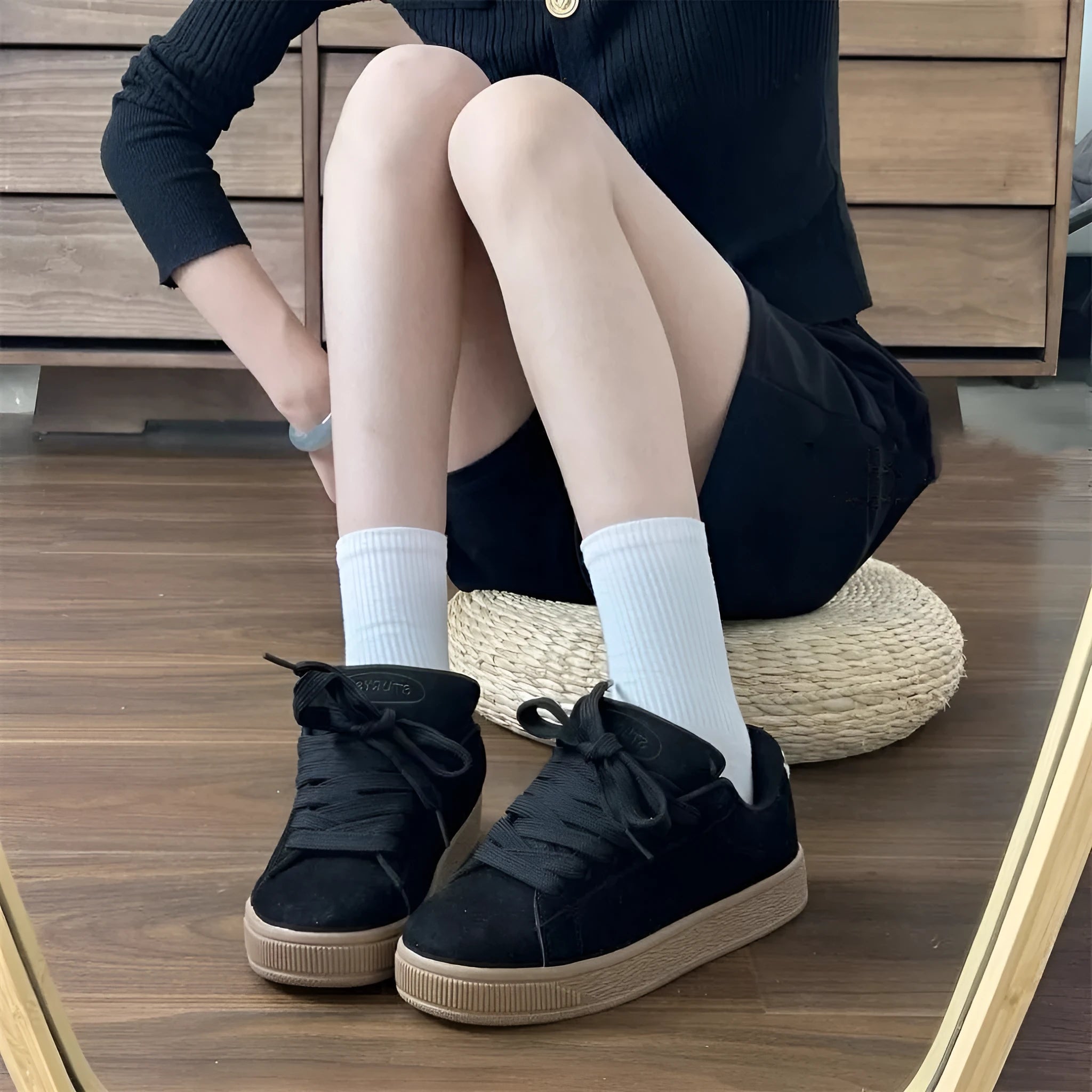 Black retro low-top sneakers with round toe and front lace-up closure on injection-moulded rubber sole