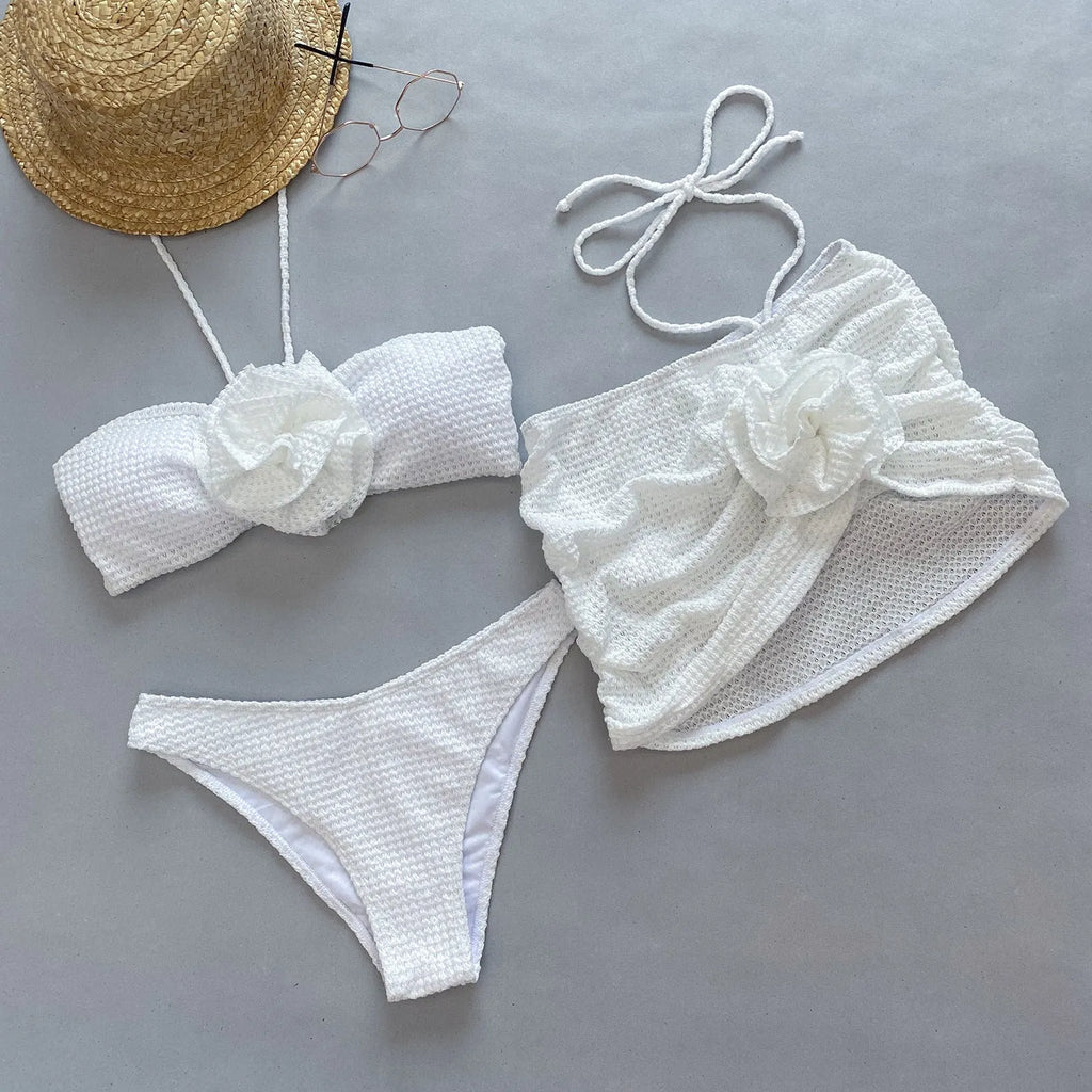 Women's white three-piece bikini swimsuit with separate bra, panties, and skirt on hanger