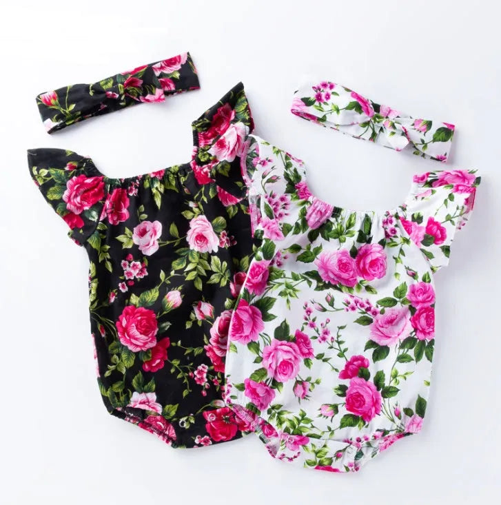 Baby girl in a black cotton romper with small flying sleeves print, showing sleeveless triangle climbing style.