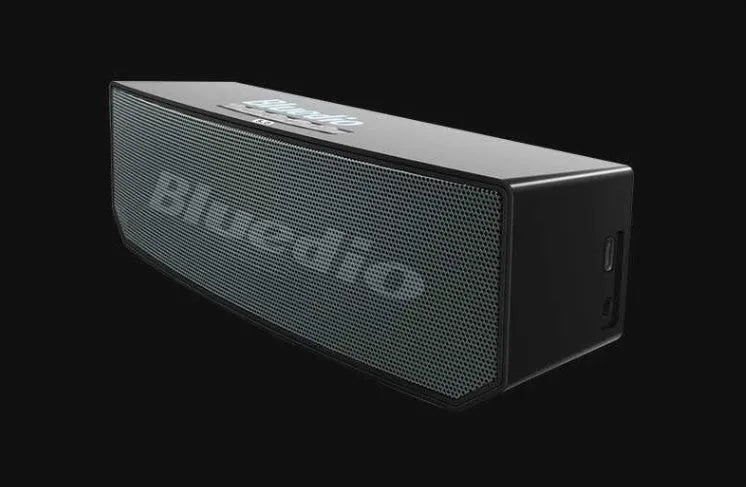 Black BS-6 Google Assistant Bluetooth smart speaker on a surface, showing its compact rectangular design.