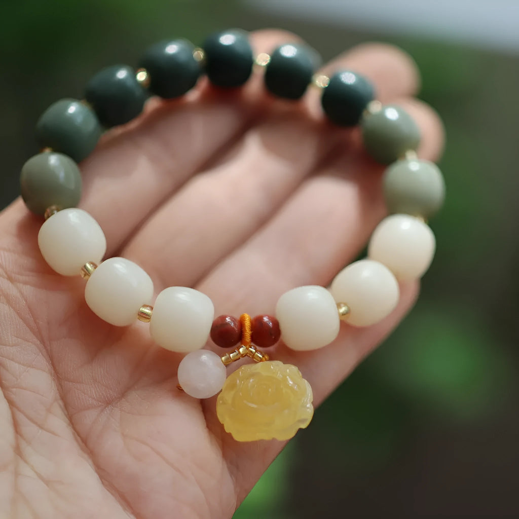 Woven bodhi bracelet with gradient white jade beads and natural beeswax lotus pendant on wrist