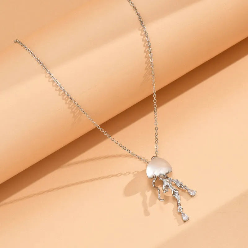 18K gold titanium steel openwork jellyfish pendant on silver O-ring chain against white background
